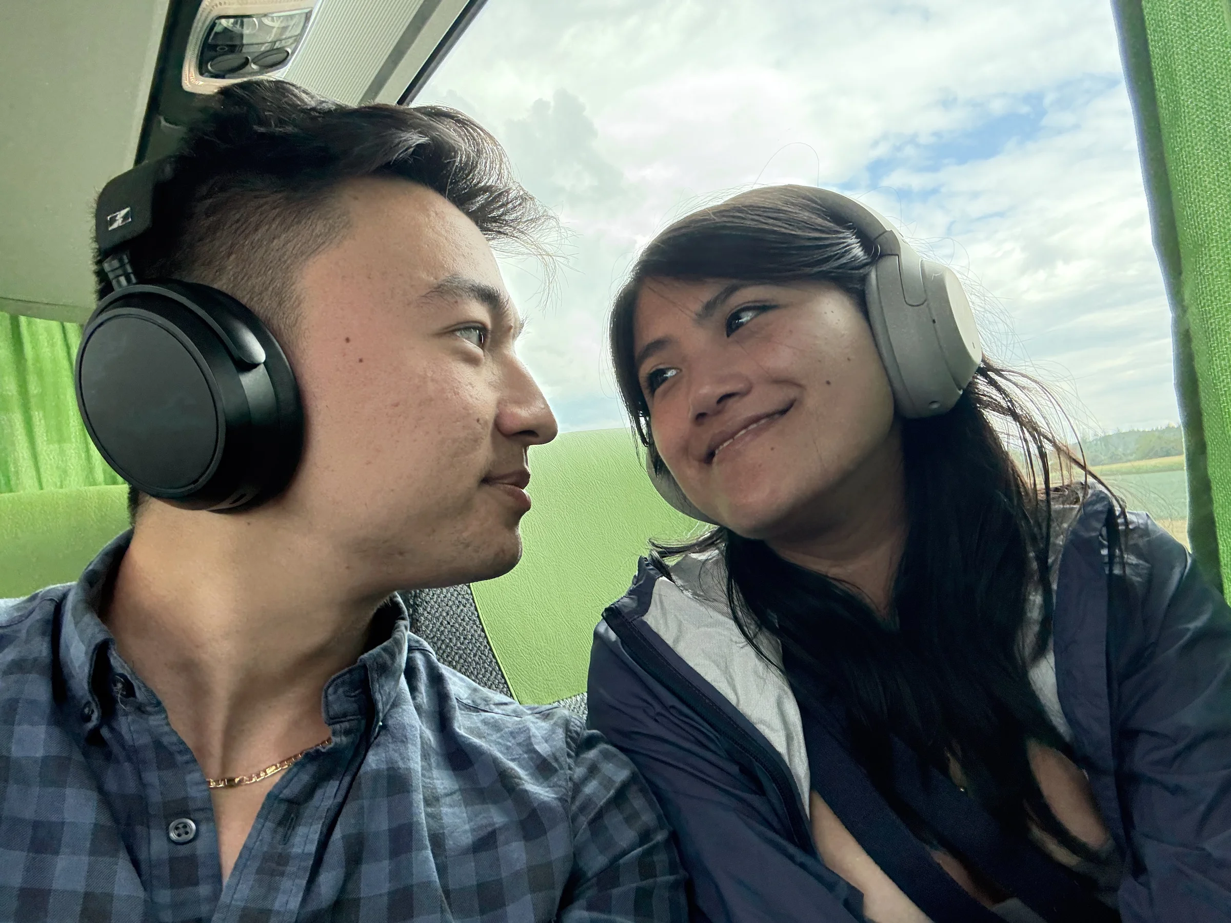 Geoff and Olivia looking at each other wearing headphones